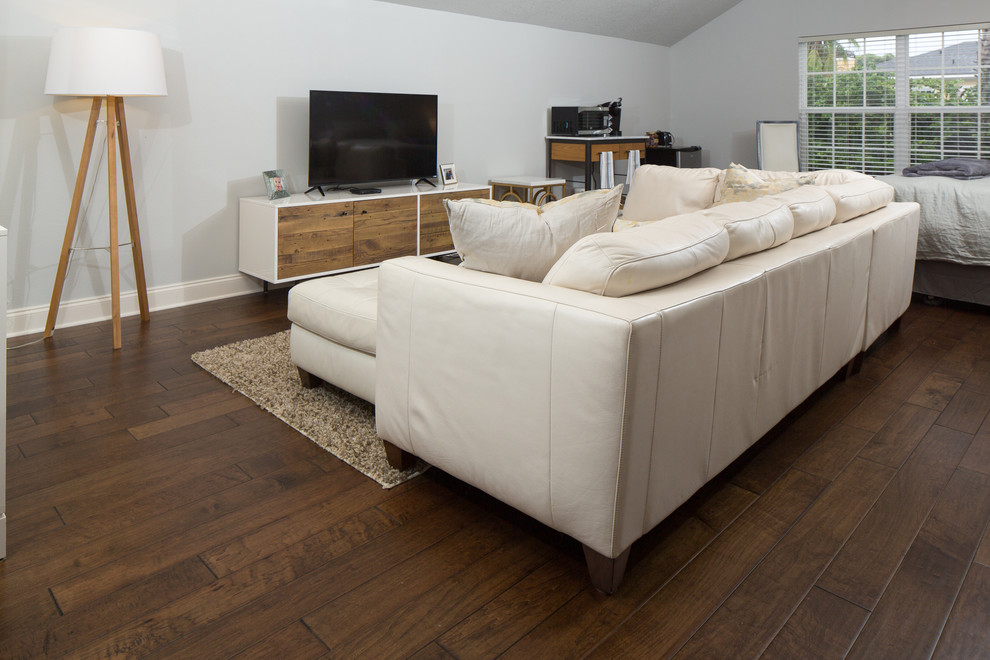 Exemple d'une grande salle de séjour mansardée ou avec mezzanine chic avec un sol en bois brun et un téléviseur indépendant.
