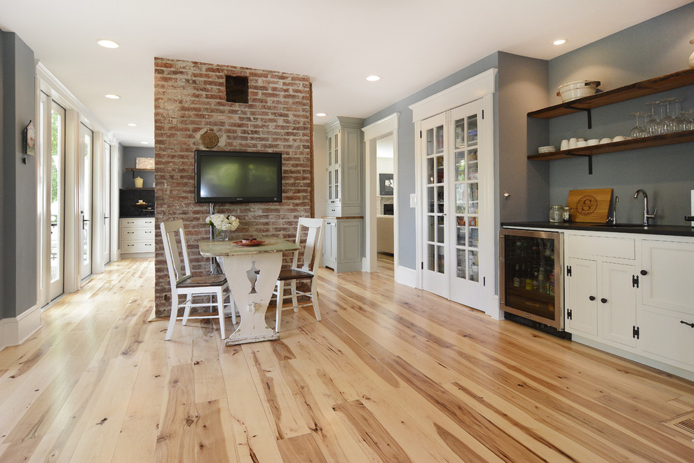 Example of a large urban open concept light wood floor family room design in Newark with a bar, gray walls, no fireplace and a wall-mounted tv