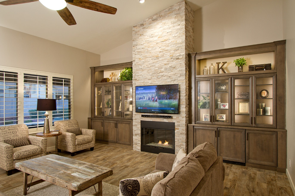Offenes Klassisches Wohnzimmer mit grauer Wandfarbe, Porzellan-Bodenfliesen, Kamin, Kaminumrandung aus Stein und TV-Wand in Phoenix