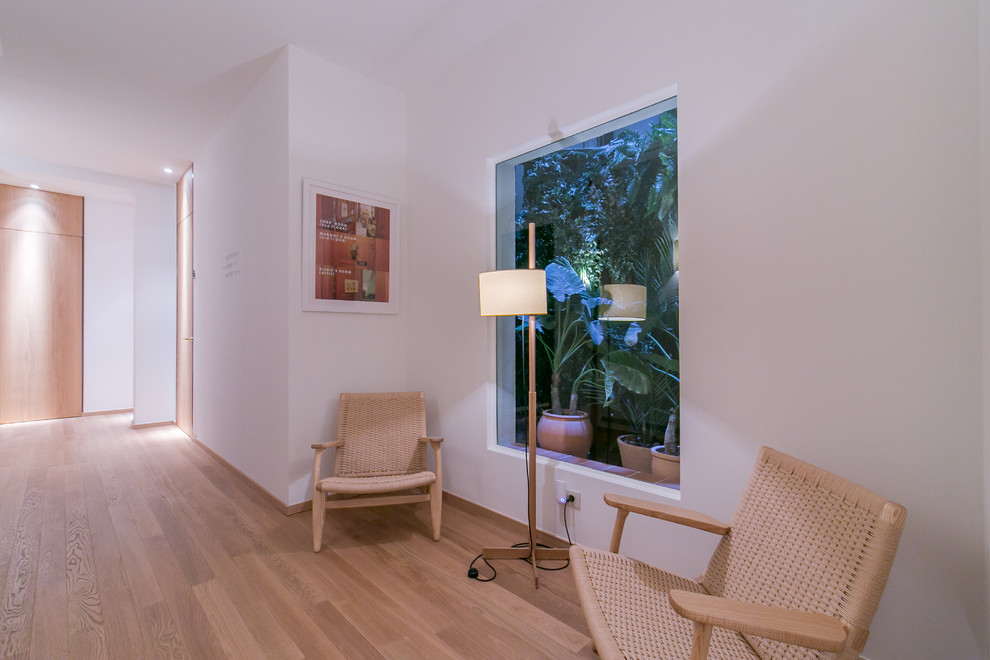 Ejemplo de sala de estar abierta nórdica pequeña sin chimenea y televisor con paredes blancas y suelo de madera en tonos medios