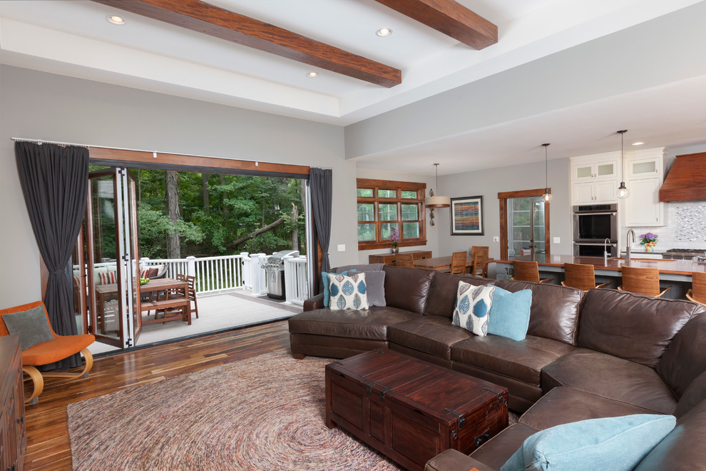 Ejemplo de sala de estar abierta de estilo americano de tamaño medio sin chimenea con paredes grises, suelo de madera en tonos medios y televisor independiente