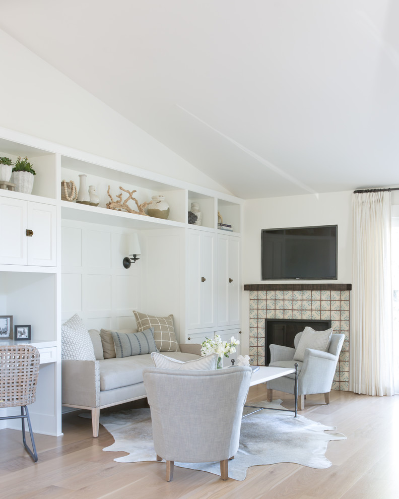 Inspiration for a coastal light wood floor and beige floor family room remodel in San Francisco with white walls, a standard fireplace, a tile fireplace and a wall-mounted tv