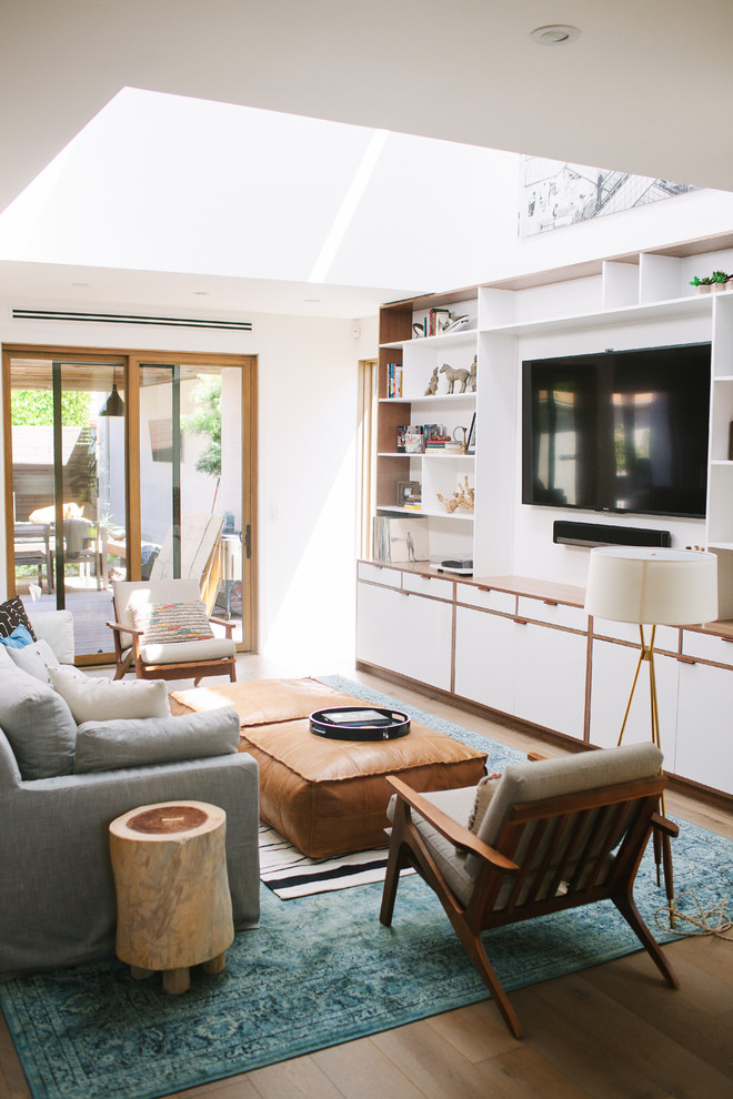 Источник вдохновения для домашнего уюта: гостиная комната в морском стиле с белыми стенами, темным паркетным полом, телевизором на стене и коричневым полом
