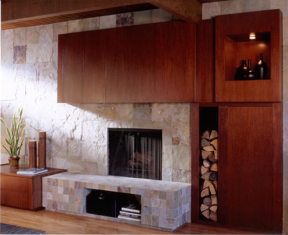 Photo of a large contemporary enclosed games room in San Francisco with a standard fireplace, a stone fireplace surround, light hardwood flooring, beige walls, a concealed tv and beige floors.