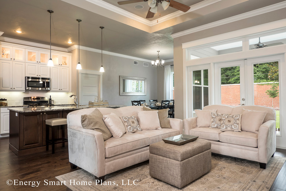 Imagen de sala de estar abierta de estilo americano pequeña con paredes beige y suelo de madera en tonos medios