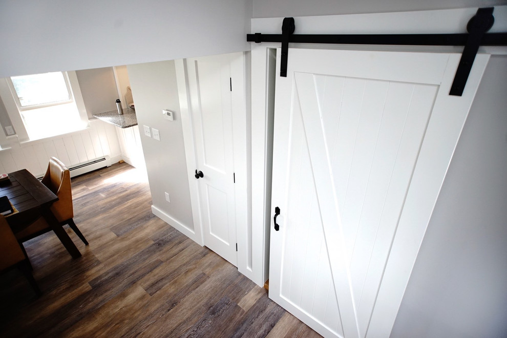 На фото: открытая гостиная комната среднего размера в стиле модернизм с серыми стенами, полом из ламината и коричневым полом с