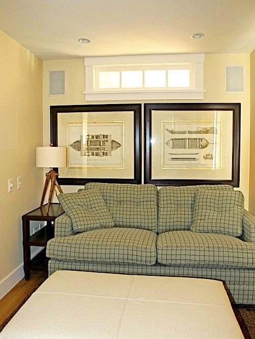 Ejemplo de sala de estar con biblioteca cerrada marinera pequeña con paredes amarillas y suelo de madera en tonos medios