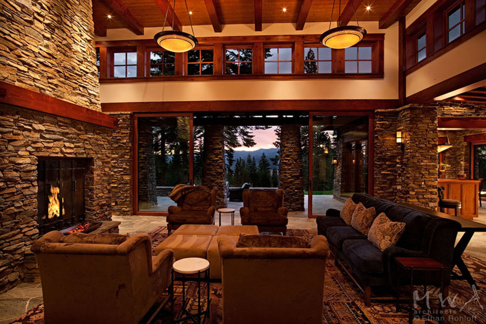 Exemple d'une grande salle de séjour craftsman ouverte avec un mur beige, une cheminée standard et un manteau de cheminée en pierre.