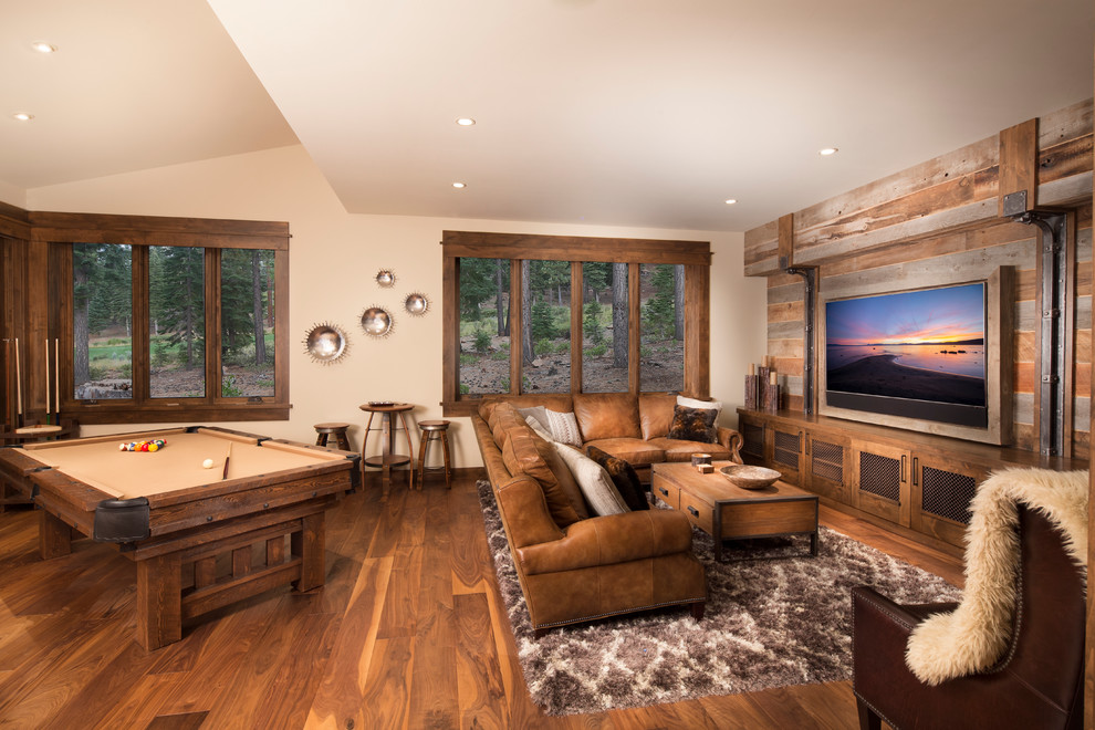 Imagen de sala de estar rural con paredes beige, suelo de madera oscura y televisor colgado en la pared