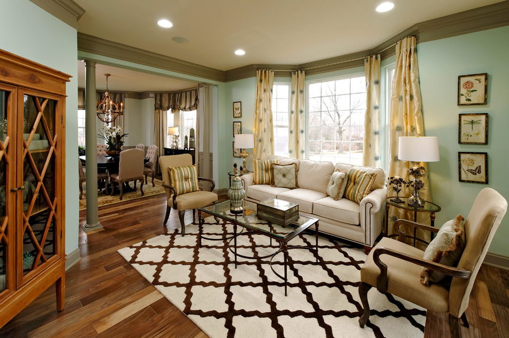 Diseño de sala de estar abierta tradicional con paredes azules y suelo de madera en tonos medios