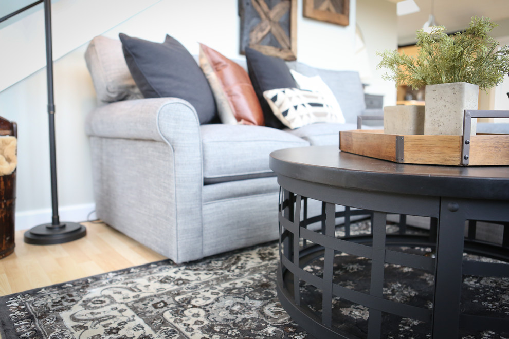 Foto de sala de estar abierta tradicional renovada de tamaño medio sin televisor con paredes grises, suelo de madera clara, estufa de leña y marco de chimenea de metal