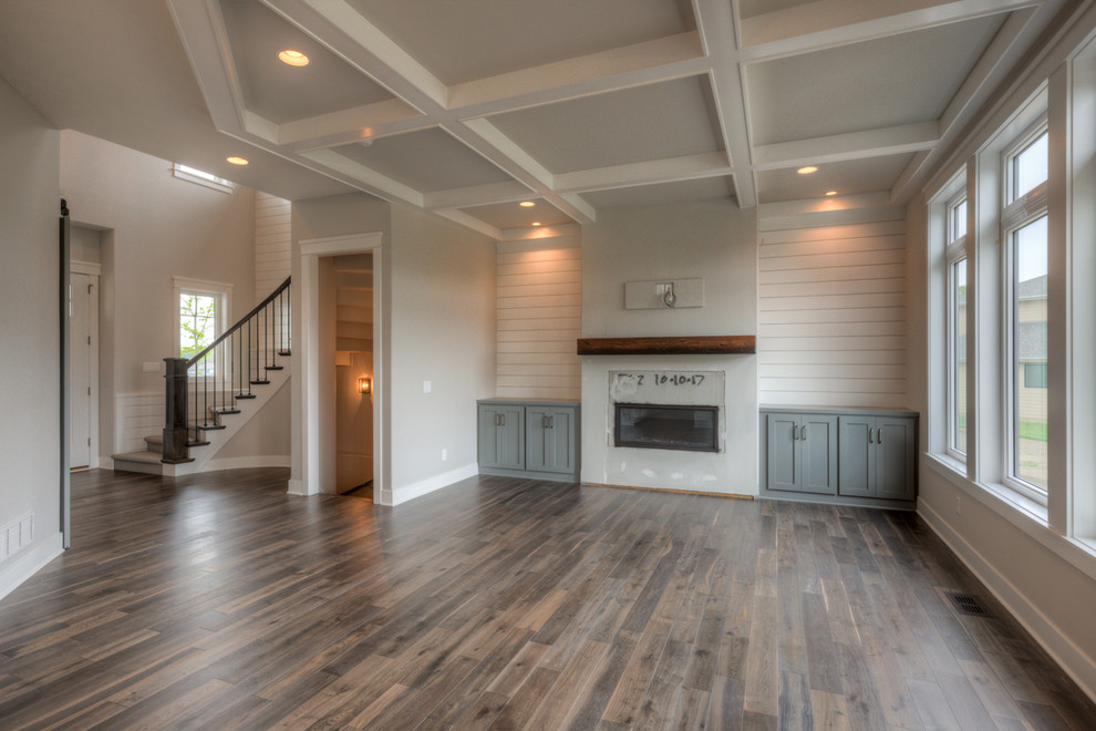 This is an example of a large open plan games room in Omaha with a standard fireplace and a wall mounted tv.