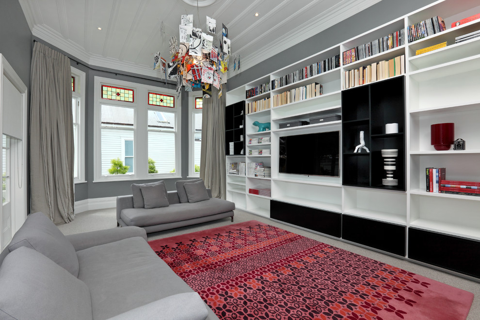 На фото: гостиная комната в современном стиле с серыми стенами, мультимедийным центром и ковром на полу с