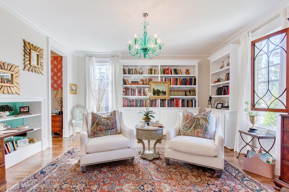 Ispirazione per un soggiorno classico chiuso con libreria, pareti beige e pavimento in legno massello medio