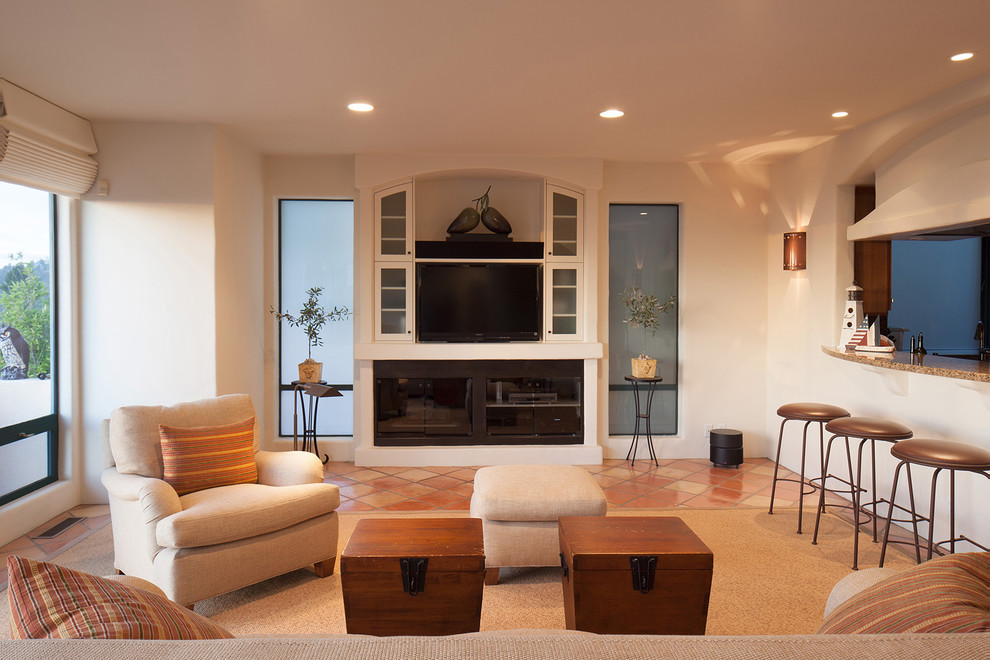 Imagen de sala de estar abierta mediterránea extra grande con paredes beige, suelo de baldosas de terracota, televisor independiente y suelo naranja
