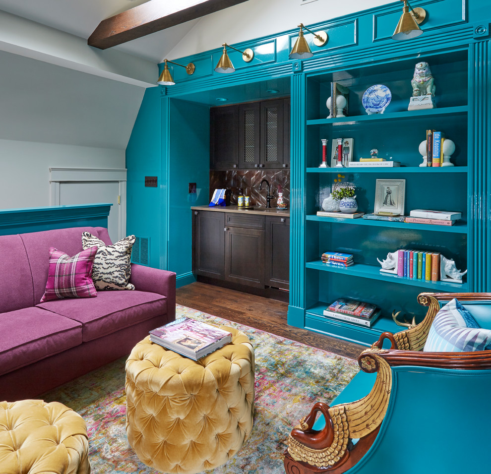Cette image montre une salle de séjour bohème fermée avec un bar de salon, un mur bleu et parquet foncé.