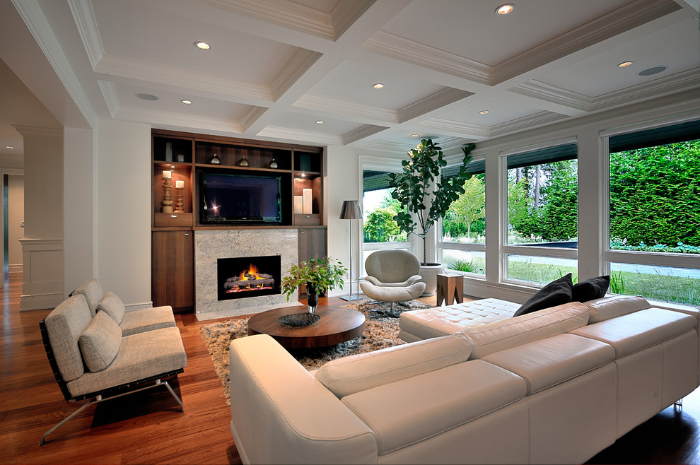 Offenes Modernes Wohnzimmer mit weißer Wandfarbe, braunem Holzboden, Kamin und TV-Wand in Vancouver