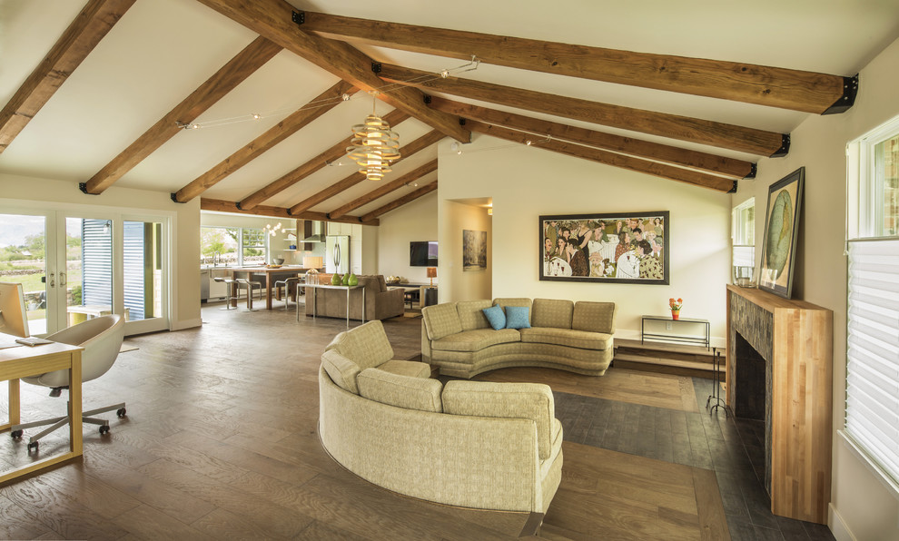 Modelo de sala de estar abierta actual de tamaño medio con paredes blancas, suelo de madera en tonos medios, todas las chimeneas y televisor colgado en la pared
