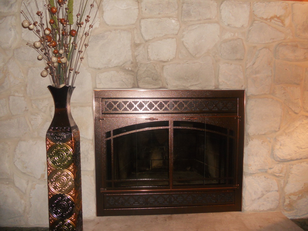 Foto de sala de estar clásica con marco de chimenea de piedra y todas las chimeneas