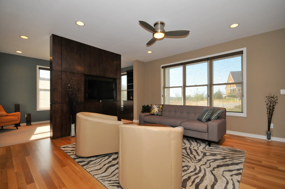 Ejemplo de sala de estar contemporánea con paredes beige, suelo de madera en tonos medios y televisor colgado en la pared