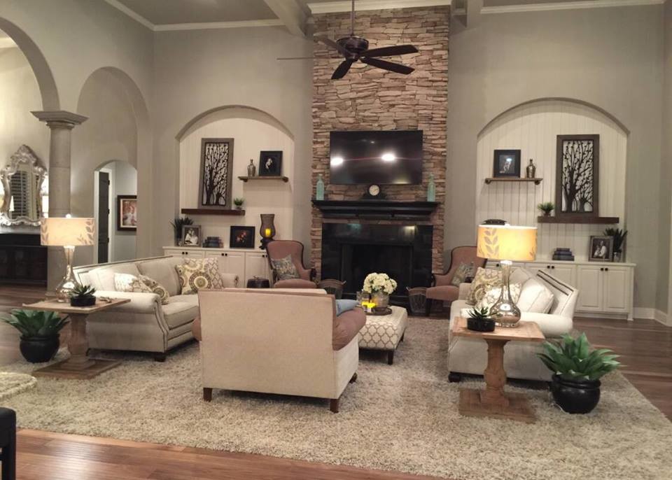 Großes, Offenes Shabby-Style Wohnzimmer mit beiger Wandfarbe, braunem Holzboden, Kamin, Kaminumrandung aus Stein und TV-Wand in Austin