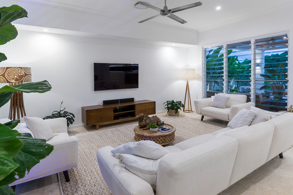На фото: гостиная комната среднего размера в морском стиле с белыми стенами, телевизором на стене и бежевым полом с
