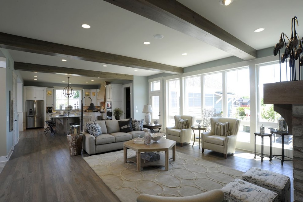 Example of a beach style open concept vinyl floor, gray floor and exposed beam family room design in Columbus with blue walls, a standard fireplace, a brick fireplace and a media wall