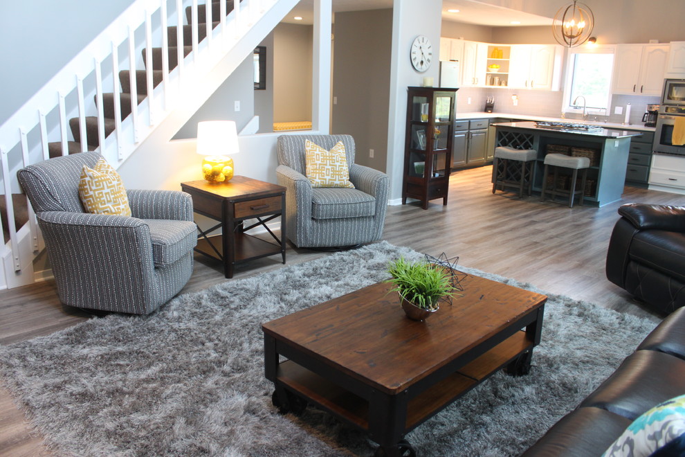 Mittelgroßes, Offenes Modernes Wohnzimmer mit grauer Wandfarbe, braunem Holzboden, Kamin, verputzter Kaminumrandung und TV-Wand in Grand Rapids