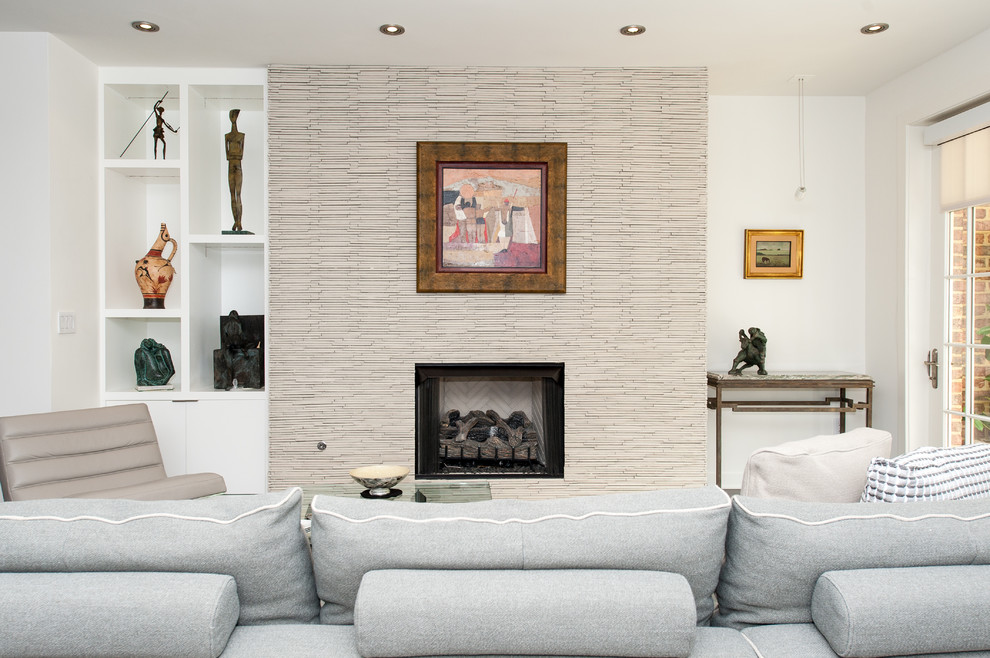 Esempio di un piccolo soggiorno design aperto con pareti bianche, parquet scuro, camino classico e cornice del camino in pietra