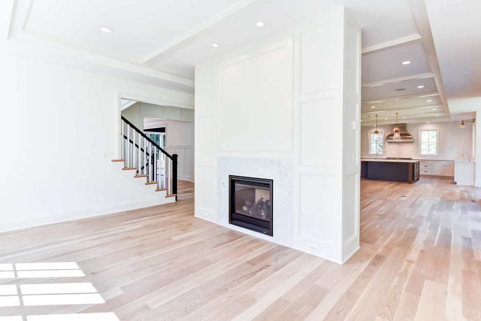 ワシントンD.C.にある巨大なトラディショナルスタイルのおしゃれなオープンリビング (白い壁、無垢フローリング、両方向型暖炉、木材の暖炉まわり、茶色い床) の写真