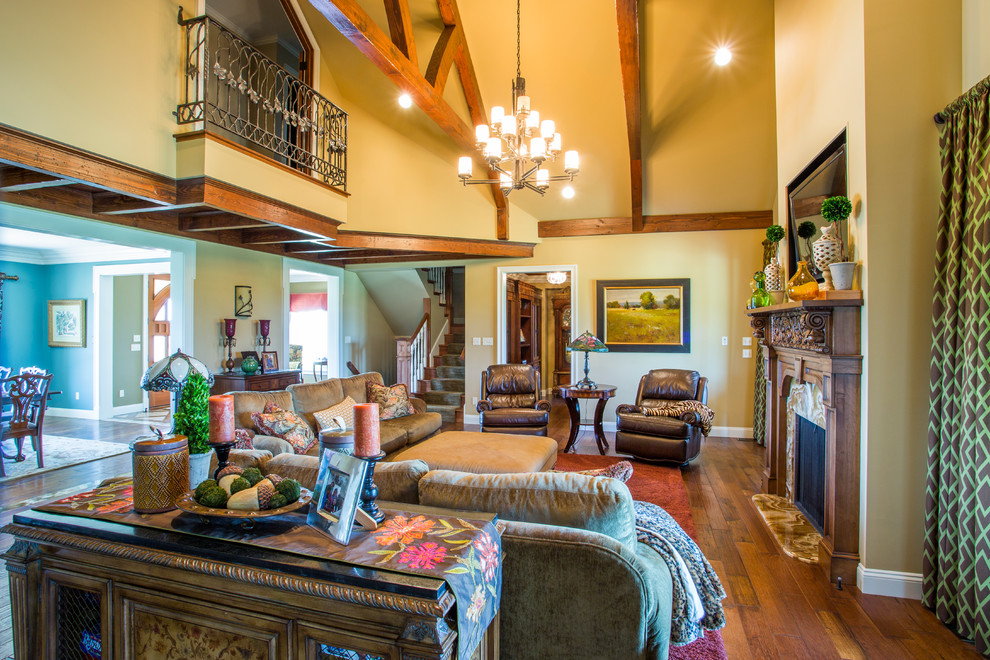Example of a large classic open concept medium tone wood floor and brown floor family room design in Other with beige walls, a standard fireplace, a stone fireplace and a wall-mounted tv