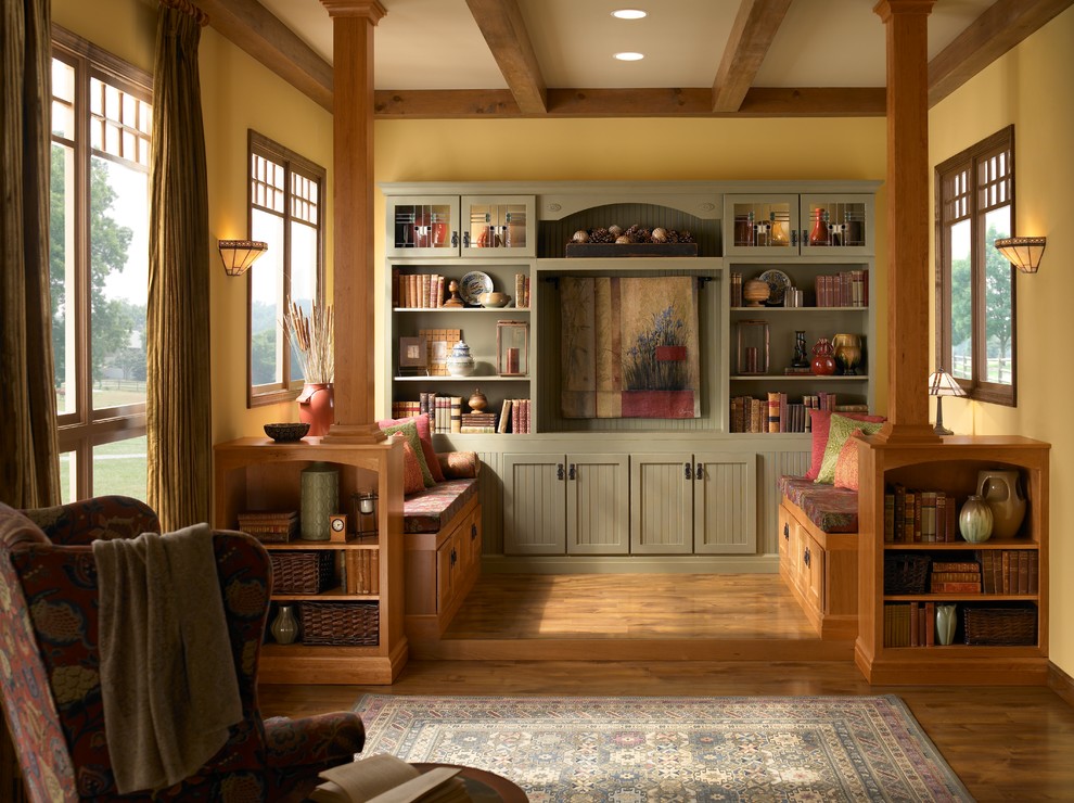 Idee per un soggiorno stile americano con libreria, pareti gialle, pavimento in legno massello medio, nessuna TV e pavimento marrone