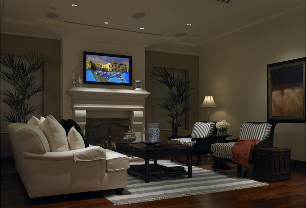 Ejemplo de sala de estar cerrada contemporánea de tamaño medio con televisor retractable, paredes beige, suelo de madera en tonos medios y todas las chimeneas