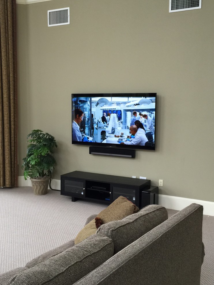 Imagen de sala de estar cerrada tradicional grande sin chimenea con paredes grises, moqueta, televisor colgado en la pared y suelo beige