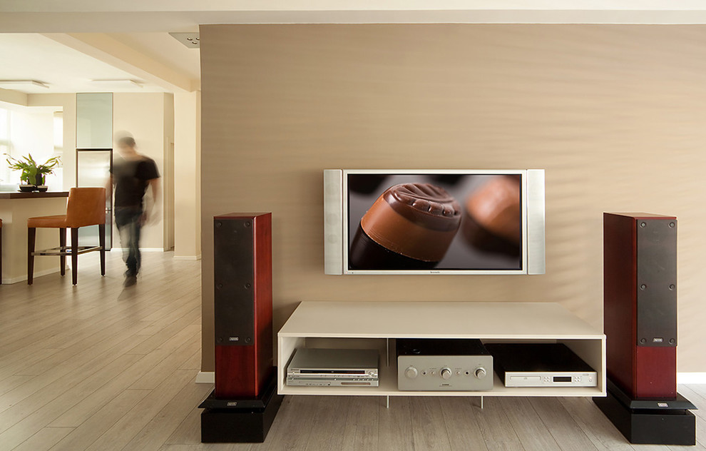 Modelo de sala de estar contemporánea con paredes beige, suelo de madera clara y televisor colgado en la pared