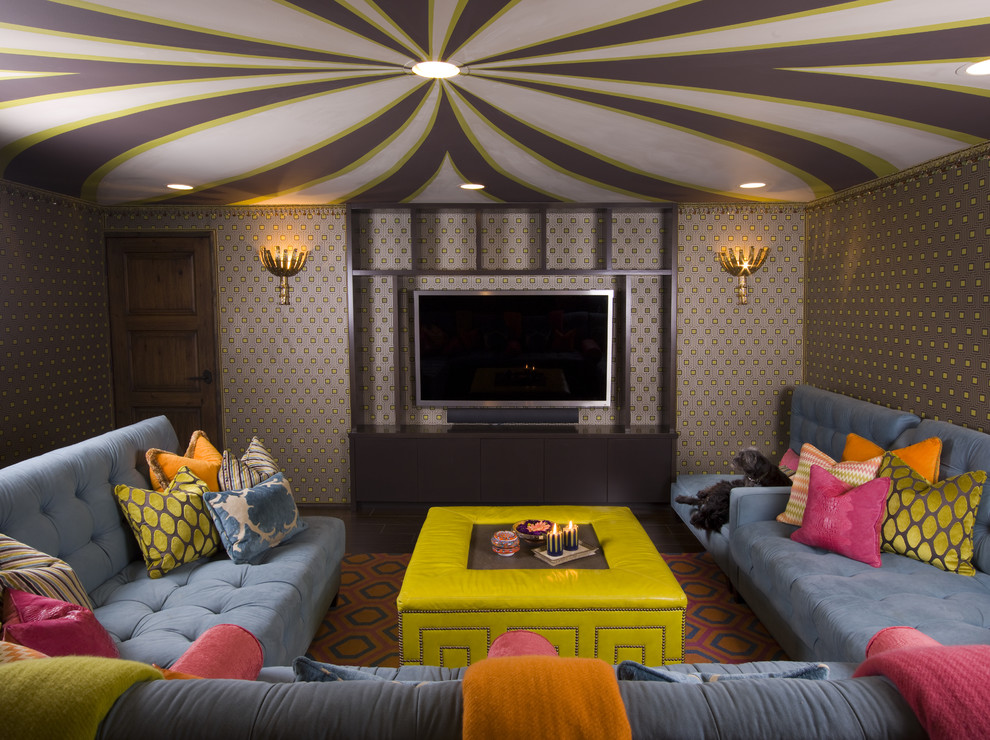 На фото: изолированная гостиная комната в стиле фьюжн с телевизором на стене, разноцветными стенами и синим диваном с