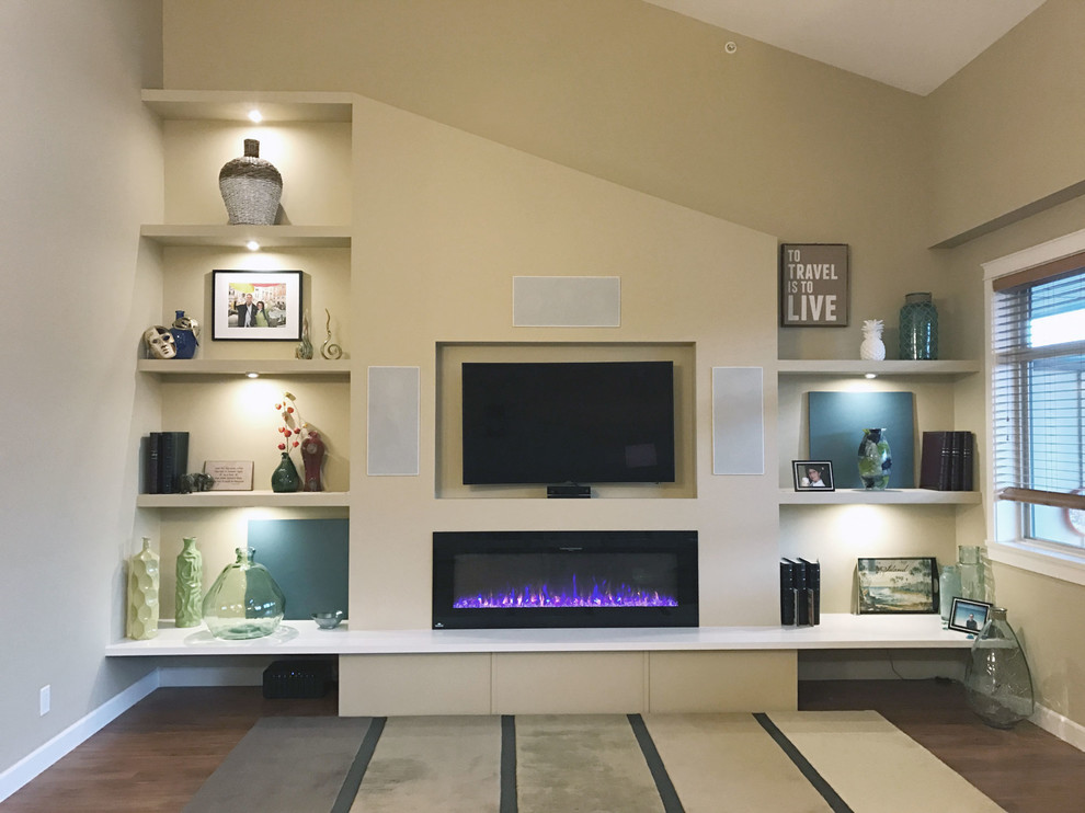 This is an example of a small classic open plan games room in Vancouver with beige walls, laminate floors, a hanging fireplace and a built-in media unit.