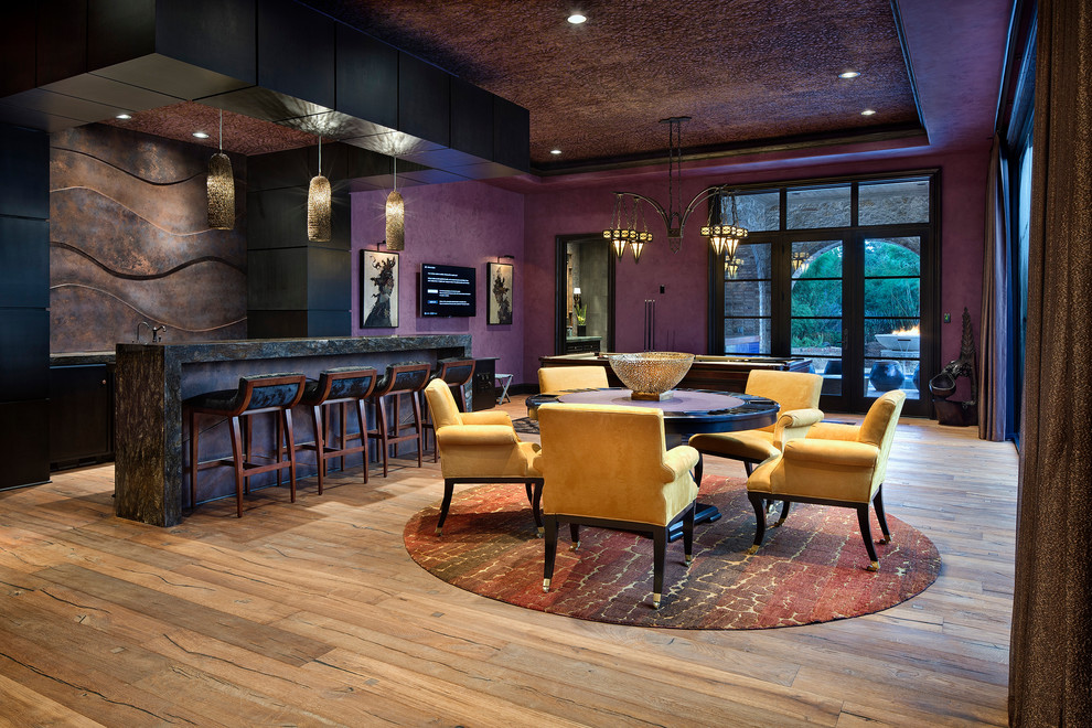 Стильный дизайн: открытая гостиная комната в средиземноморском стиле с фиолетовыми стенами, светлым паркетным полом и телевизором на стене - последний тренд