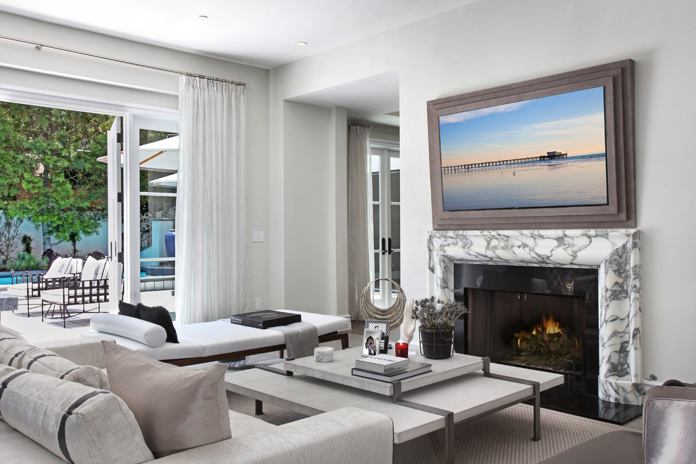 Example of a tuscan family room design in Los Angeles with white walls, a standard fireplace and a wall-mounted tv
