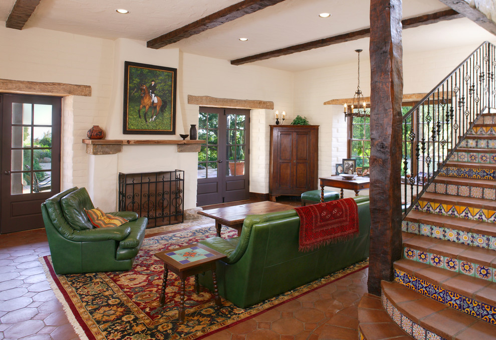 Mediterranes Wohnzimmer mit Terrakottaboden, Kamin, weißer Wandfarbe und braunem Boden in Santa Barbara