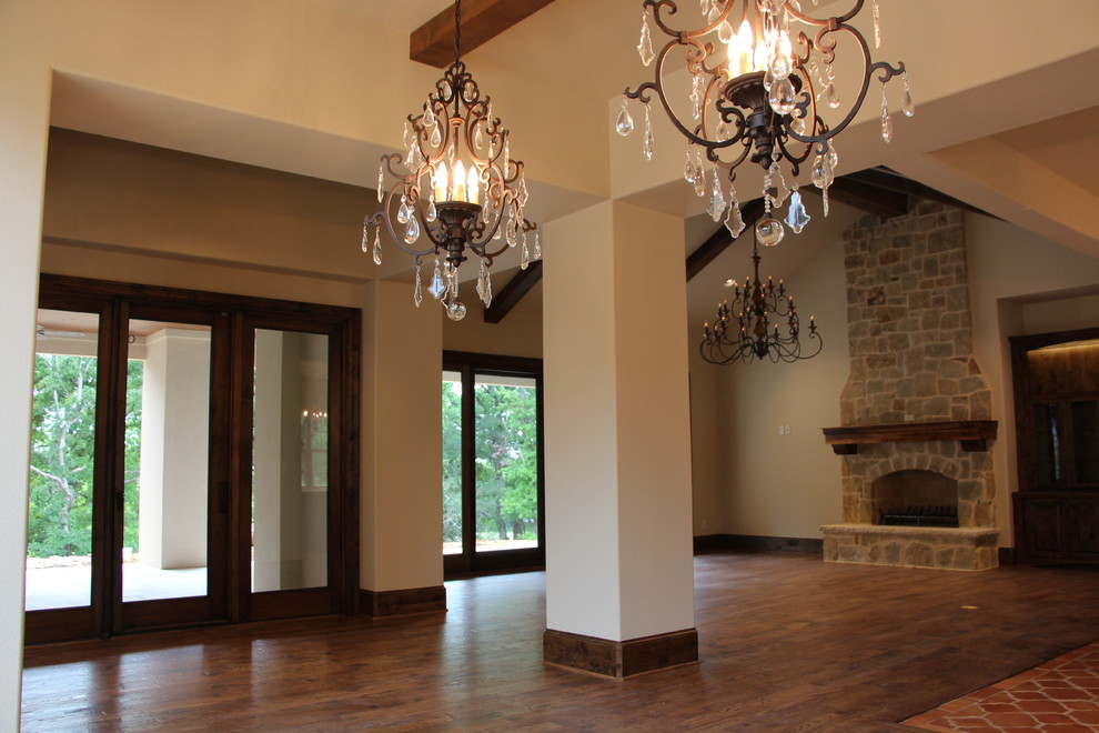 Example of a huge tuscan open concept medium tone wood floor family room design in Dallas with beige walls, a standard fireplace and a stone fireplace