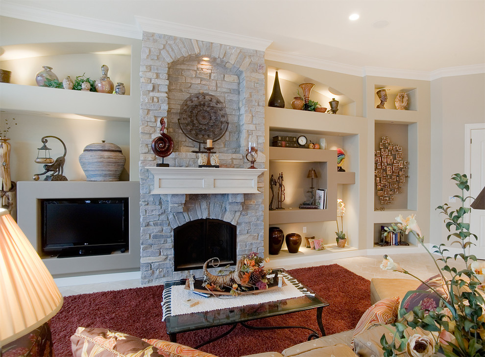 Modelo de sala de estar abierta mediterránea grande con paredes beige, suelo de baldosas de cerámica, todas las chimeneas, marco de chimenea de piedra y pared multimedia