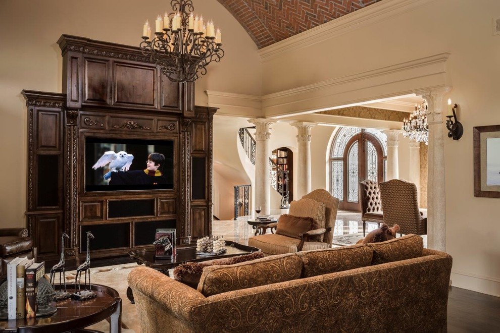 Diseño de sala de estar abierta mediterránea grande con suelo de madera oscura, paredes beige, todas las chimeneas, marco de chimenea de piedra y pared multimedia