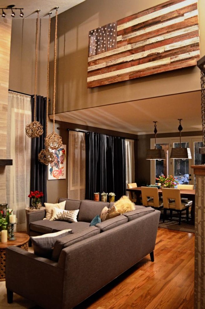 Diseño de sala de estar con barra de bar ecléctica grande con paredes grises, suelo de madera en tonos medios, todas las chimeneas, marco de chimenea de baldosas y/o azulejos y televisor independiente