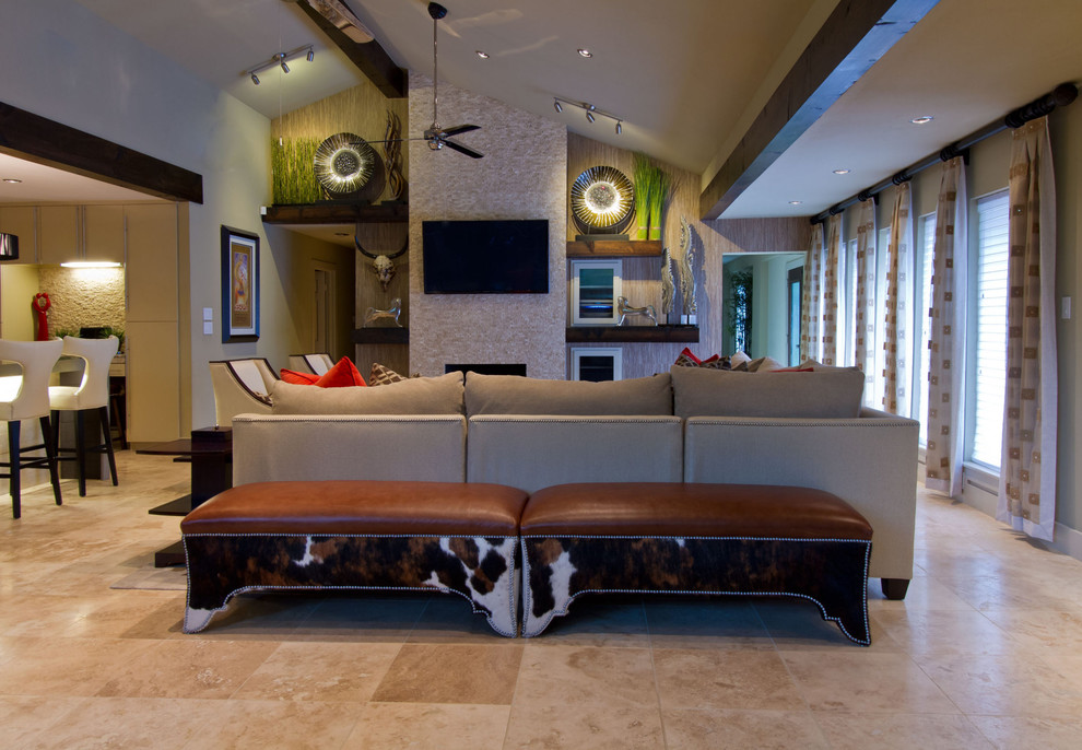 Modelo de sala de estar abierta moderna extra grande con paredes beige, suelo de travertino, todas las chimeneas, marco de chimenea de piedra y televisor colgado en la pared