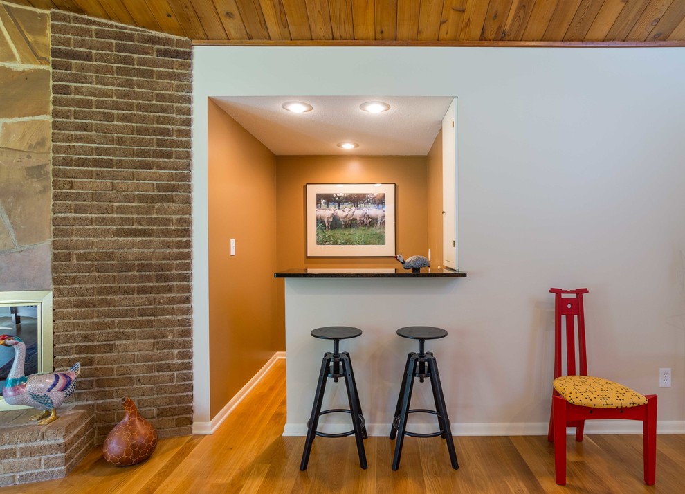 Стильный дизайн: открытая гостиная комната среднего размера в современном стиле с домашним баром, коричневыми стенами и паркетным полом среднего тона - последний тренд