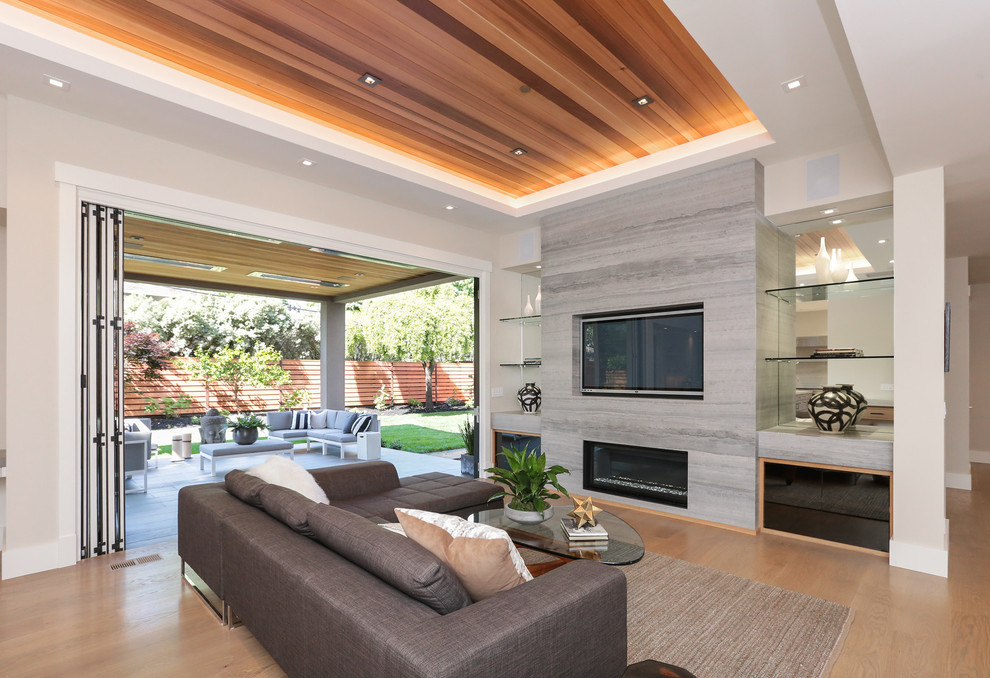 Photo of a large contemporary open plan games room in San Francisco with grey walls, light hardwood flooring, a ribbon fireplace, a stone fireplace surround, a built-in media unit and grey floors.