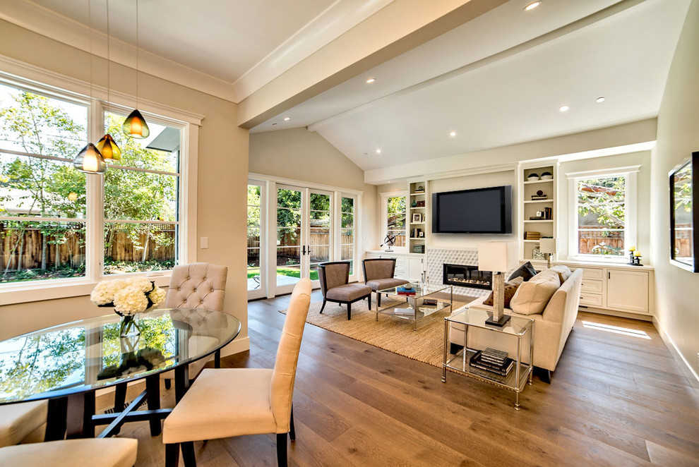 Elegant open concept medium tone wood floor and beige floor family room photo in San Francisco with beige walls, a wall-mounted tv, a ribbon fireplace and a plaster fireplace