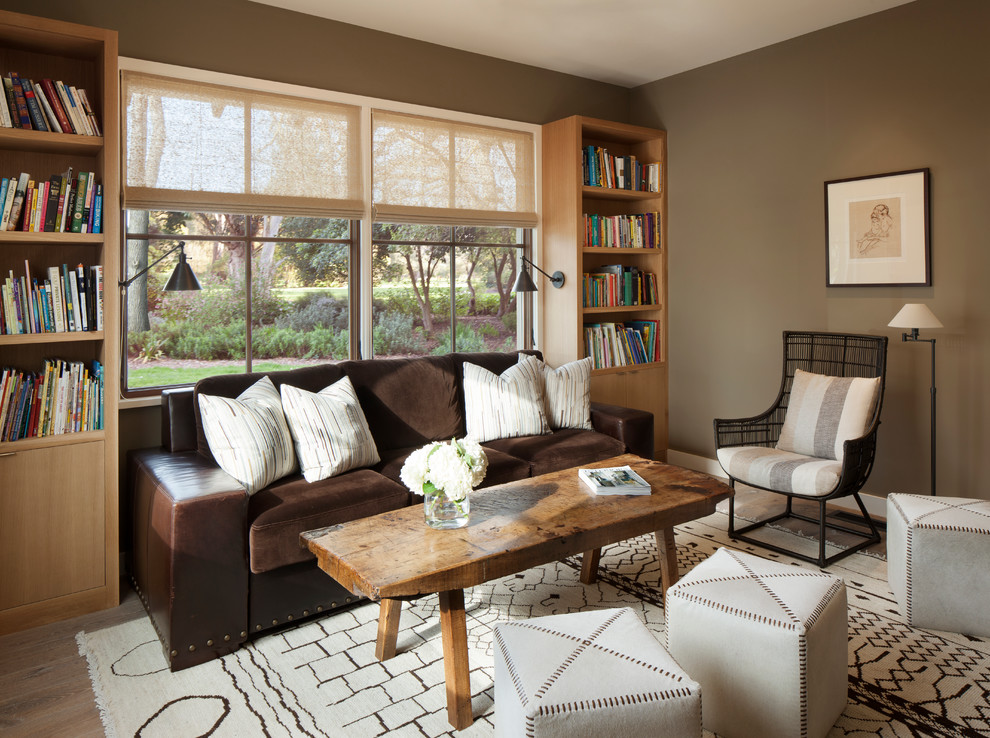 На фото: гостиная комната в стиле неоклассика (современная классика) с коричневыми стенами, светлым паркетным полом и с книжными шкафами и полками