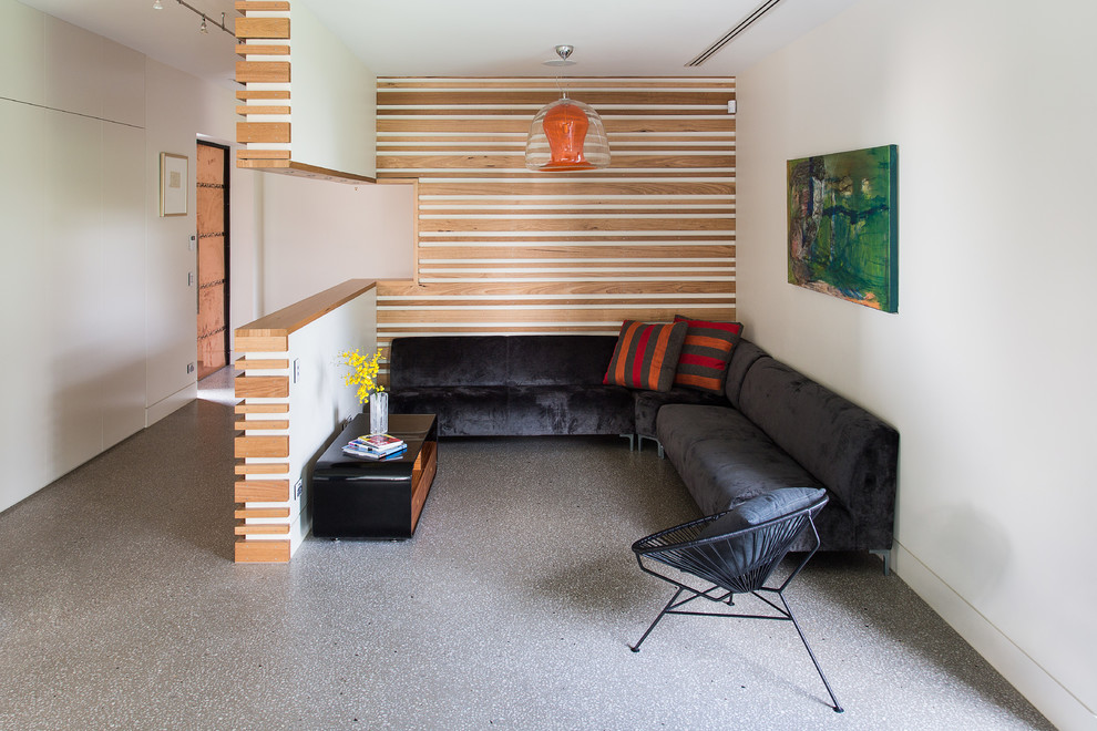 Идея дизайна: маленькая открытая гостиная комната в современном стиле с белыми стенами, бетонным полом и акцентной стеной без камина, телевизора для на участке и в саду